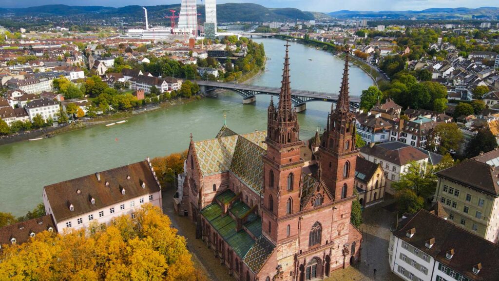 Drohnenbild der Stadt Basel. Das Münster im Vordergrund, der Rhein und die Roch-Türme im Hintergrund